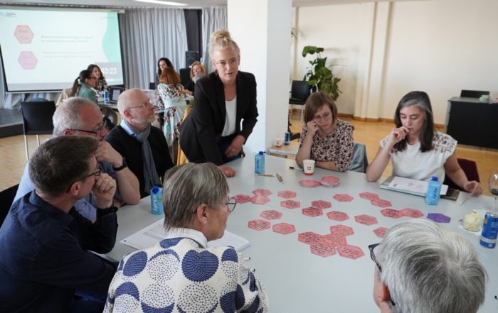 People sitting around a table with red post it notes.